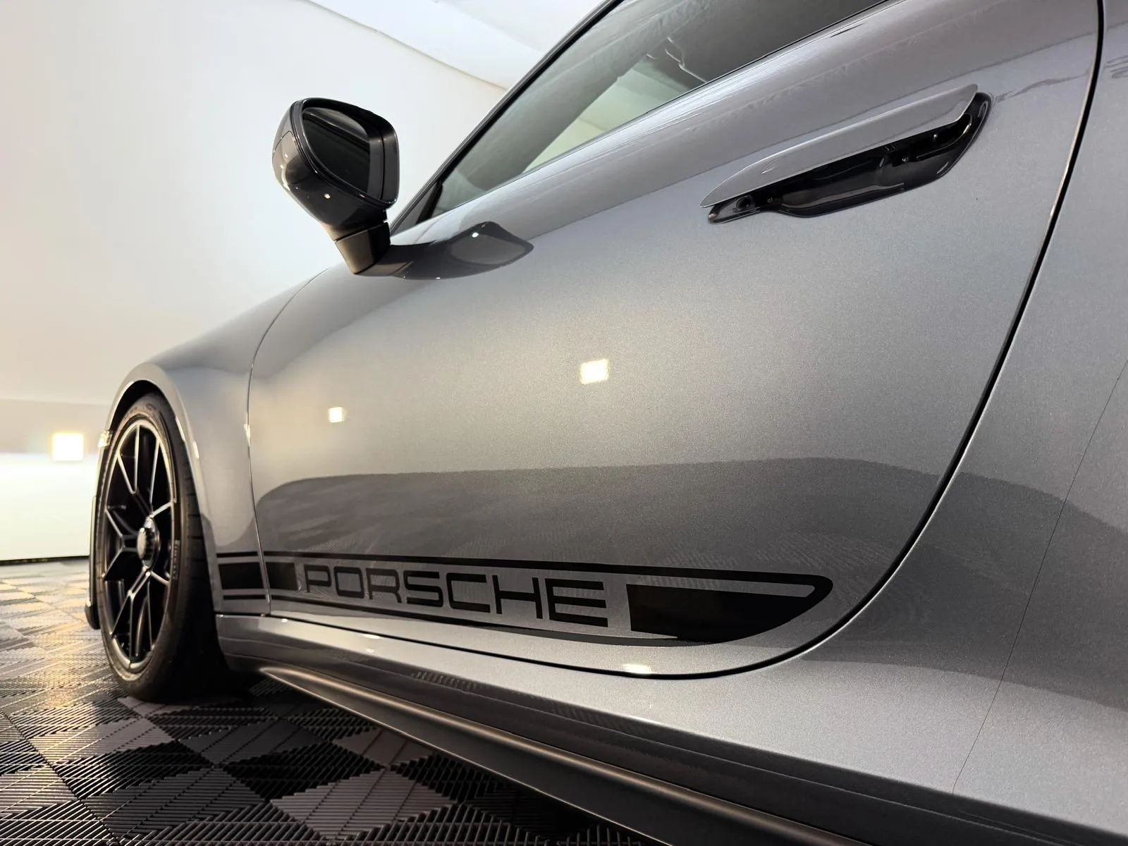 Odlesky na lesklém laku šedého Porsche 911 GT3 v showroomu Exclusive Car
